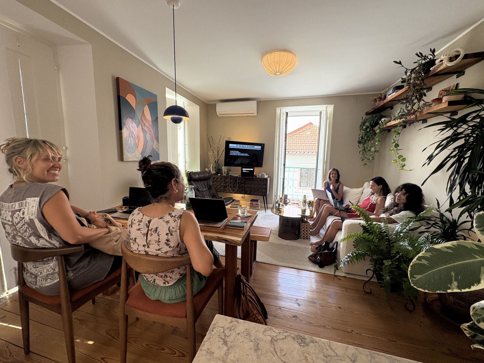 Women working at laptops in a living room class